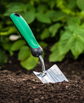 Handheld shovel sticking in soil